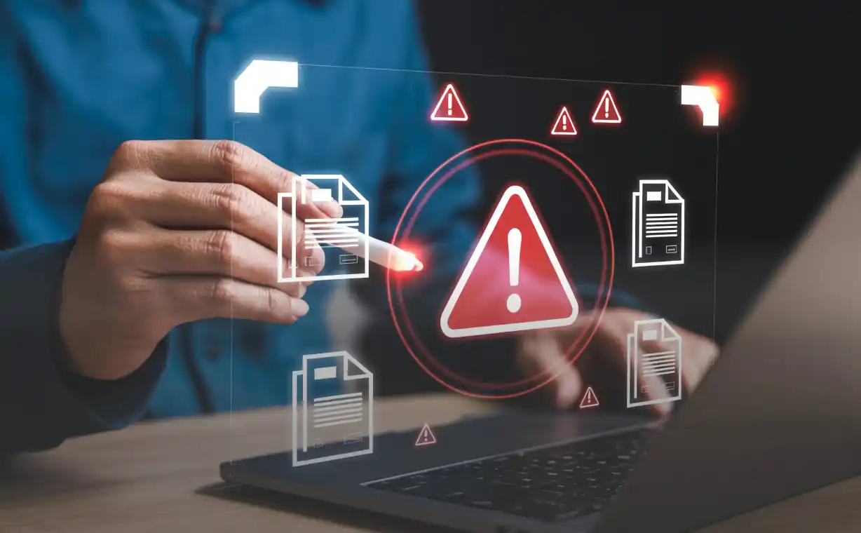 Persona analizando documentos digitales con iconos de emergencia en una laptop sobre las consecuencias de facturar sin certificado digital homologado ante la DGII